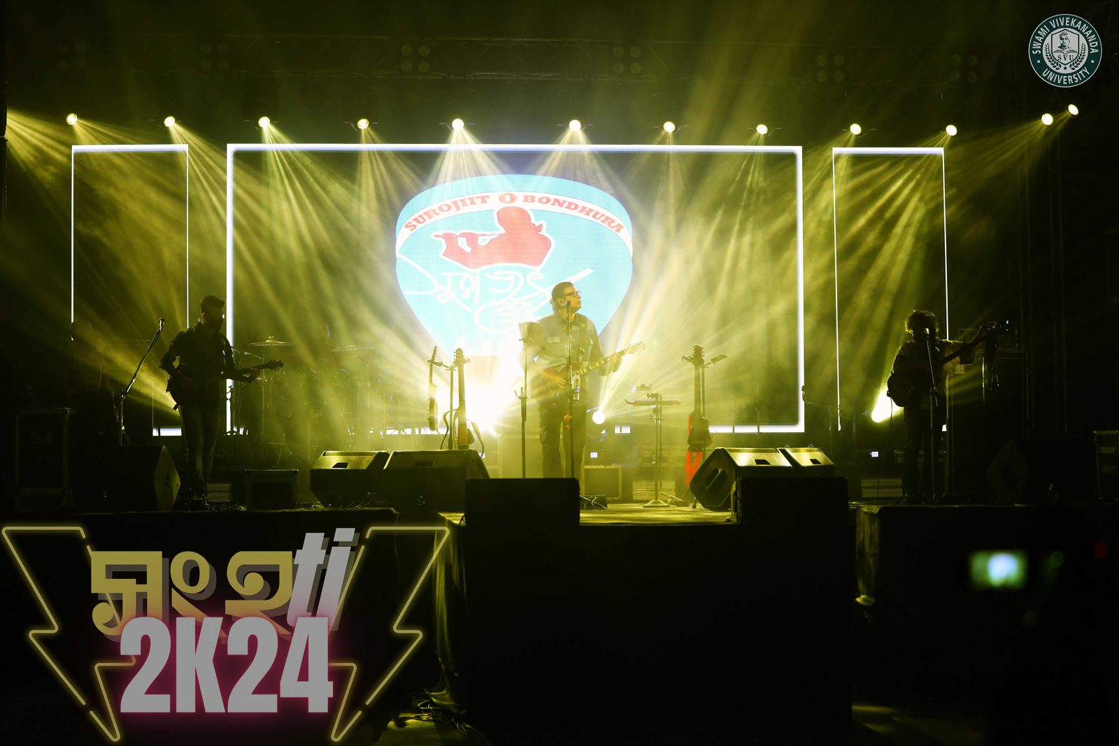 The band in silhouette across the stage, beams of light fanning out from the Surojiit O Bondhura backdrop