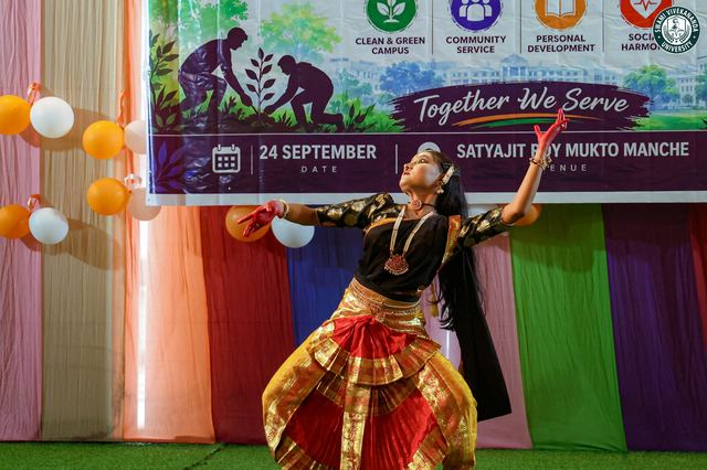 A student dancing before the "Together We Serve" backdrop